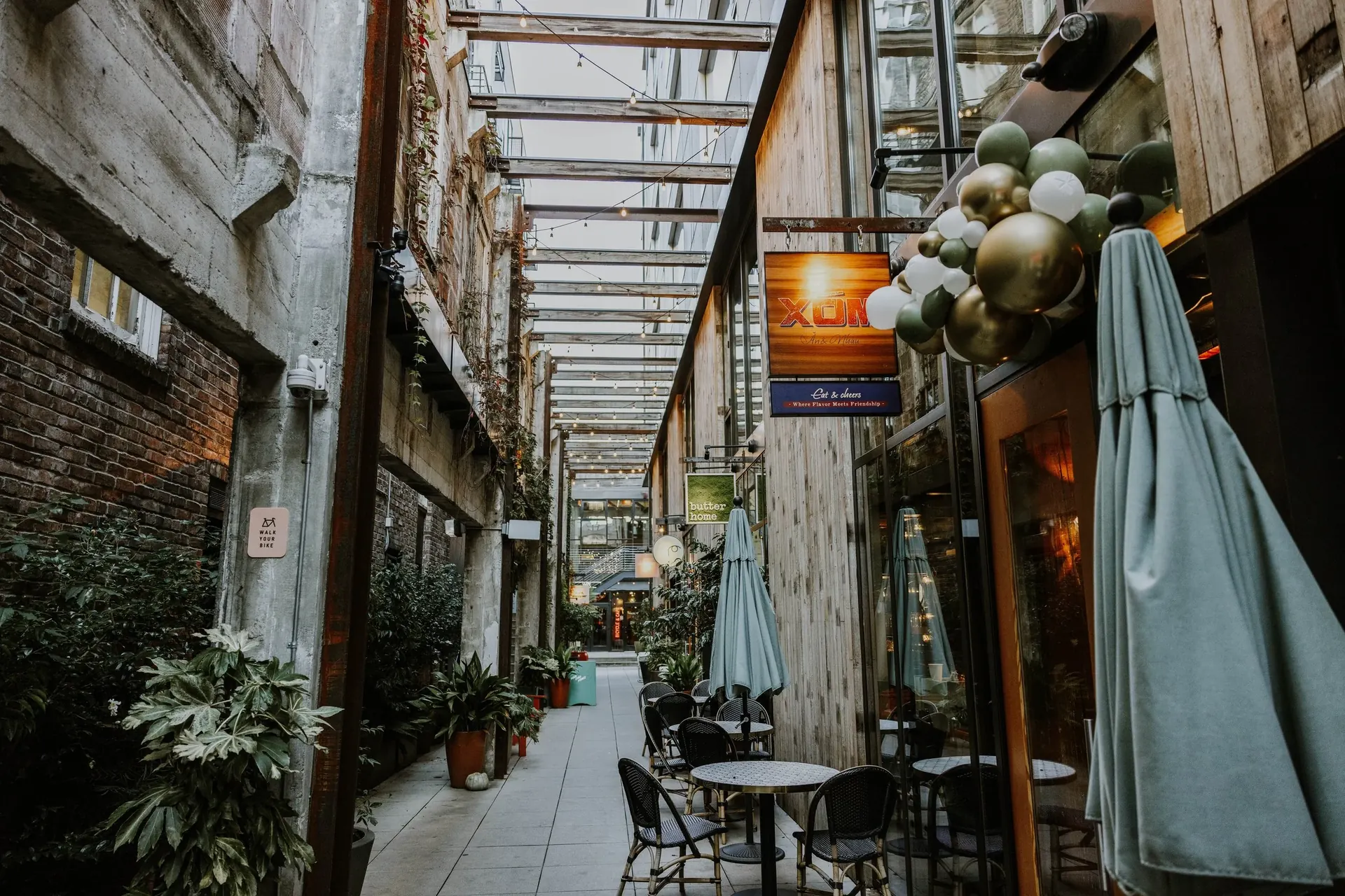The Chophouse Row courtyard — Xóm's glowing sign visible through the glass-roofed passage on 11th Ave
